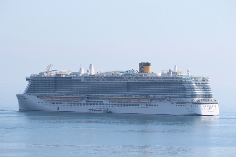 Le paquebot Costa Toscana de Costa Croisières vu de profil sur une mer calme, avec sa cheminée jaune frappée du C et les toboggans sur le pont supérieur