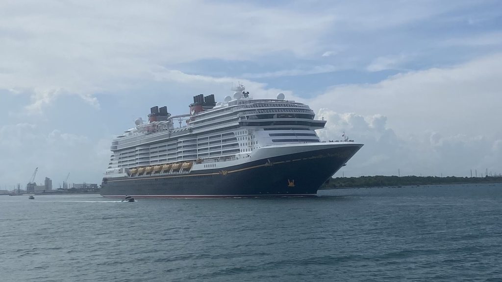 Le paquebot Disney Wish, coque bleu nuit à liseré doré et cheminées rouges et noires, naviguant dans le chenal de Port Canaveral