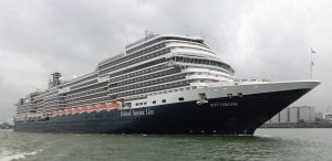 Le paquebot Rotterdam de Holland America Line, coque bleu nuit et superstructure blanche, naviguant dans le port de Rotterdam sous un ciel gris