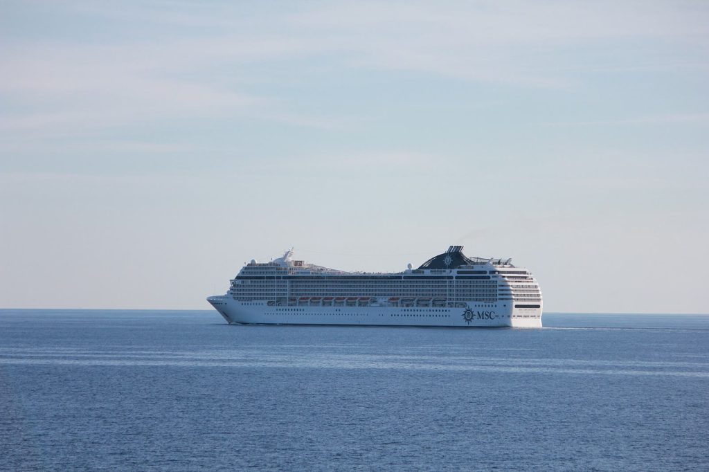 Le paquebot MSC Orchestra naviguant de profil sur une mer calme, coque blanche et cheminée bleu marine frappée du logo MSC