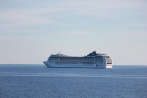 Le paquebot MSC Orchestra naviguant de profil sur une mer calme, coque blanche et cheminée bleu marine frappée du logo MSC