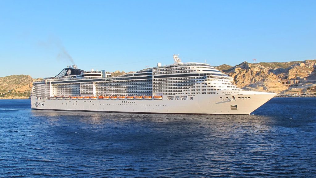 Le paquebot MSC Splendida vu de profil en mer devant les collines calcaires de Marseille, sous un ciel bleu