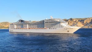 Le paquebot MSC Splendida vu de profil en mer devant les collines calcaires de Marseille, sous un ciel bleu