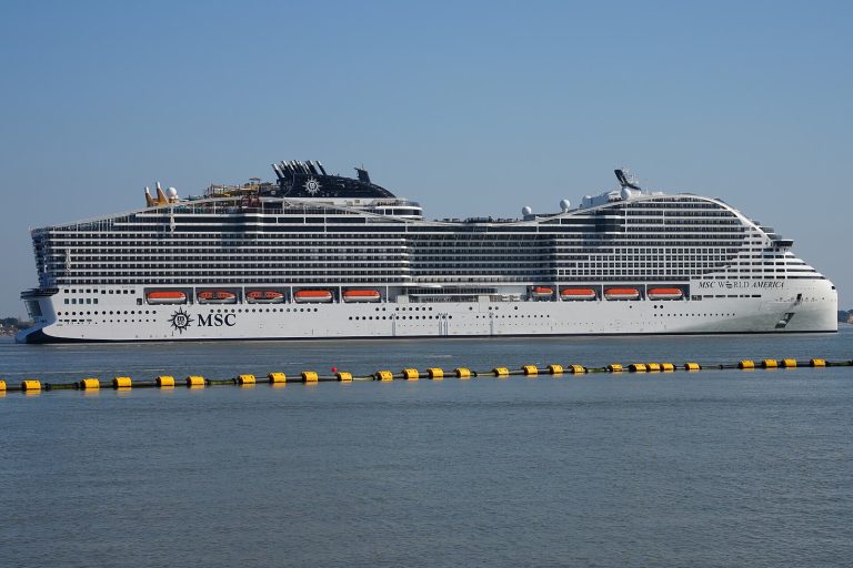 Le paquebot MSC World America de MSC Croisières vu de profil sur l'eau, avec les toboggans du parc aquatique à l'arrière