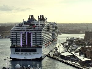 Le paquebot MSC World Europa vu de l'arrière, amarré dans le port de La Valette, avec la World Promenade éclairée au centre de la poupe et les toboggans sur le pont supérieur